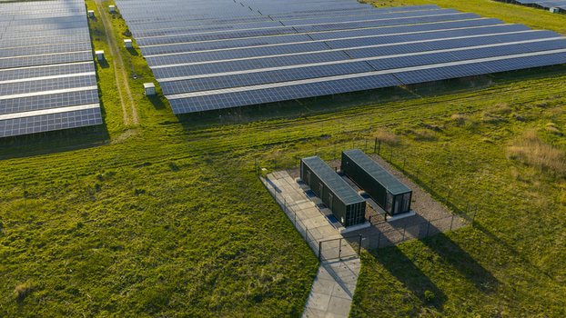 Aerial view of rows of solar panels and utility containers on a green field in Farmsum Groningen Netherlands.