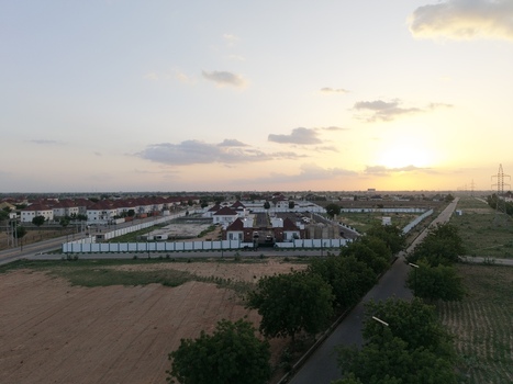 Aerial view of a modern residential complex with red roofed houses and white walls at sunset Kano Kano Nigeria.