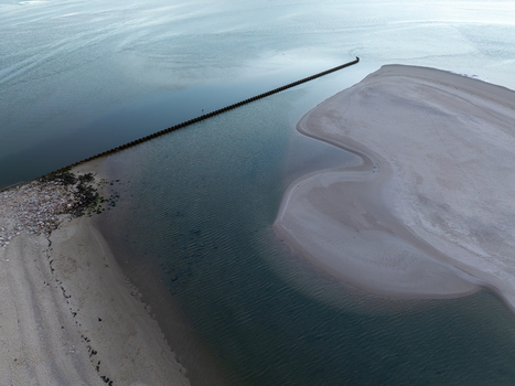 Aerial view of the Lagoa de Obidos with its sandy shores and a long breakwater extending into the calm blue waters in Foz do Arelho Leiria District Portugal. Aerial view of the Lagoa de Obidos with its sandy shores and a long breakwater extending into the calm blue waters in Foz do Arelho Leiria District Portugal.