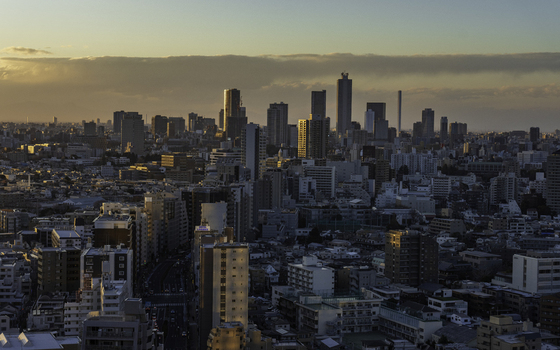 Aerial view of the modern skyscrapers pierce the skyline gilded in the warm glow of the setting sun casting long shadows across the urban landscape Bunkyo City Tokyo Japan. Aerial view of the modern skyscrapers pierce the skyline gilded in the warm glow of the setting sun casting long shadows across the urban landscape Bunkyo City Tokyo Japan.