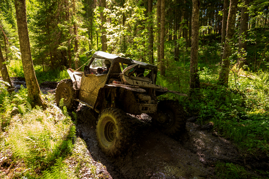 View of an off road vehicle driving through a muddy forest path near Lake Ladoga in Sortavala Respublika Kareliya Russia.