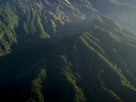 Aerial view of Bunker Kaliadem Merapi on the volcanic slopes of Mount Merapi with lush green ridges and morning mist in Kecamatan Pakem Daerah Istimewa Yogya Indonesia. Aerial view of Bunker Kaliadem Merapi on the volcanic slopes of Mount Merapi with lush green ridges and morning mist in Kecamatan Pakem Daerah Istimewa Yogya Indonesia.