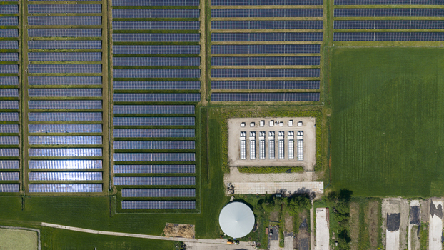 Aerial view of a large solar farm with rows of photovoltaic panels and an energy storage facility in Wanneperveen Overijssel Netherlands. Aerial view of a large solar farm with rows of photovoltaic panels and an energy storage facility in Wanneperveen Overijssel Netherlands.