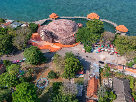 Aerial view of the giant turtle shaped building at Kura Kura Ocean Park with coastal walkways and pavilions by the sea in Jepara Central Java Indonesia. Aerial view of the giant turtle shaped building at Kura Kura Ocean Park with coastal walkways and pavilions by the sea in Jepara Central Java Indonesia.
