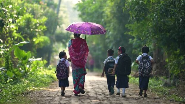View of a woman and children walking on a rural path Bangladesh.
