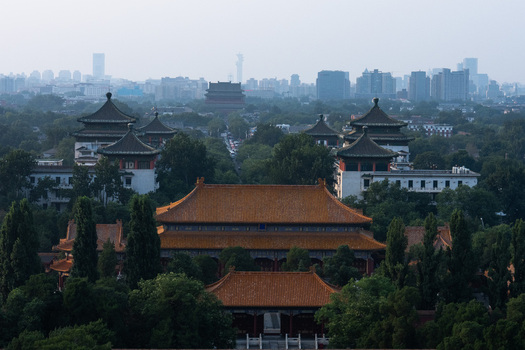 View of the Forbidden City with its iconic golden roofs and traditional Chinese architecture surrounded by lush trees and the modern skyline of Beijing Beijing China. View of the Forbidden City with its iconic golden roofs and traditional Chinese architecture surrounded by lush trees and the modern skyline of Beijing Beijing China.
