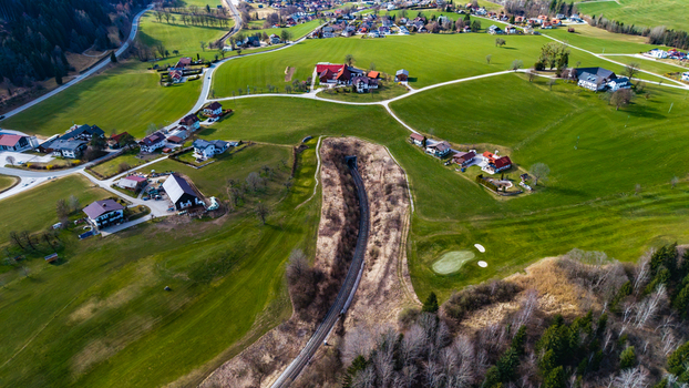 Aerial view of houses scattered across rolling green hillsides with a winding path cutting through the landscape Windischgarsten Upper Austria Austria. Aerial view of houses scattered across rolling green hillsides with a winding path cutting through the landscape Windischgarsten Upper Austria Austria.