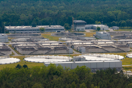 Aerial view of the wastewater treatment plant with circular sedimentation tanks and rectangular aeration basins set within a forest landscape Warsaw Masovian Voivodeship Poland. Aerial view of the wastewater treatment plant with circular sedimentation tanks and rectangular aeration basins set within a forest landscape Warsaw Masovian Voivodeship Poland.
