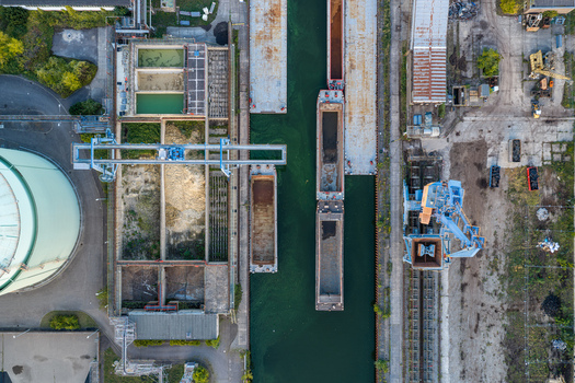 Aerial view of Heizkraftwerk Klingenberg combined heat and power plant with industrial barges docked in the canal storage tanks and cranes in Berlin Berlin Germany. Aerial view of Heizkraftwerk Klingenberg combined heat and power plant with industrial barges docked in the canal storage tanks and cranes in Berlin Berlin Germany.