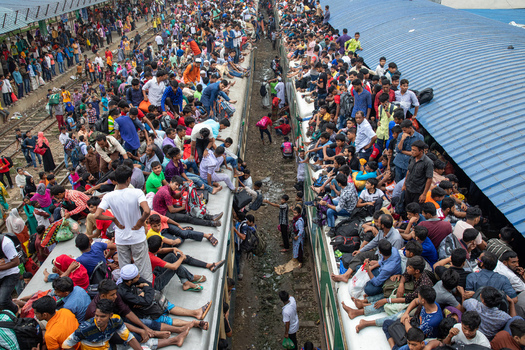 Dhaka Bangladesh 15 June 2018 View of a massive crowd of people sitting on the roofs of trains at Airport Railway Station during the Eid al Fitr rush. Dhaka Bangladesh 15 June 2018 View of a massive crowd of people sitting on the roofs of trains at Airport Railway Station during the Eid al Fitr rush.