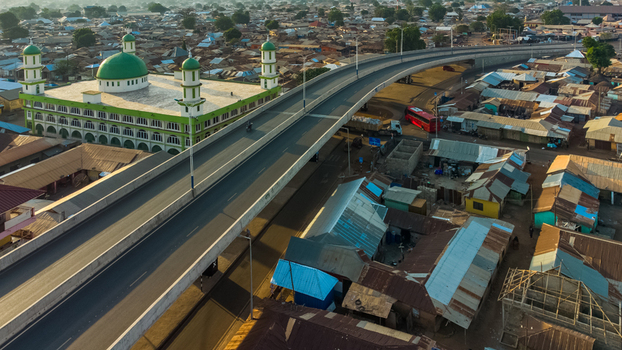 Aerial view of Tamale Central Mosque with its green domes situated next to an elevated highway and dense urban rooftops in Tamale Northern Region Ghana. Aerial view of Tamale Central Mosque with its green domes situated next to an elevated highway and dense urban rooftops in Tamale Northern Region Ghana.