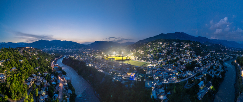 Aerial view of Muzaffarabad Cricket Stadium illuminated at night surrounded by city lights the Neelum River and the Himalayan foothills in Muzaffarabad Azad Kashmir Pakistan. Aerial view of Muzaffarabad Cricket Stadium illuminated at night surrounded by city lights the Neelum River and the Himalayan foothills in Muzaffarabad Azad Kashmir Pakistan.