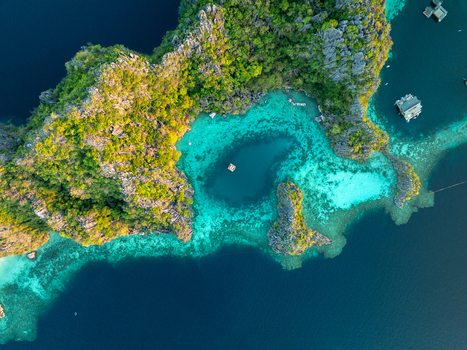 Aerial view of the turquoise waters of Twin Lagoon surrounded by dramatic limestone cliffs and lush tropical vegetation in Coron Mimaropa Philippines. Aerial view of the turquoise waters of Twin Lagoon surrounded by dramatic limestone cliffs and lush tropical vegetation in Coron Mimaropa Philippines.