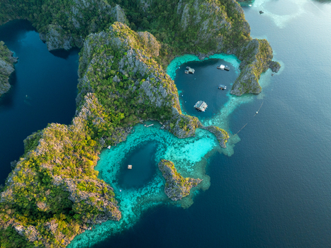 Aerial view of Twin Lagoon featuring turquoise waters surrounded by dramatic limestone cliffs and lush vegetation in Coron Mimaropa Philippines. Aerial view of Twin Lagoon featuring turquoise waters surrounded by dramatic limestone cliffs and lush vegetation in Coron Mimaropa Philippines.