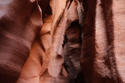 View of the narrow sandstone walls of Antelope Canyon with smooth wavy textures and warm orange light Coconino County Arizona United States.