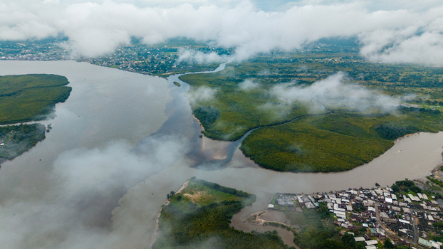 Aerial view of the Kwa Ibo River estuary with lush mangrove forests winding waterways and a coastal settlement under a cloudy sky in Kwa Ibo Akwa Ibom Nigeria.