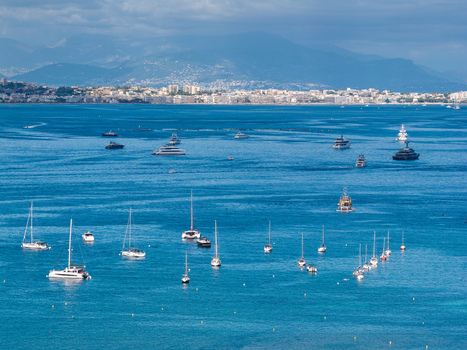 Aerial view of yachts and sailboats anchored in the turquoise waters of the bay of Cannes with the city skyline and mountains in the background in Cannes Provence Alpes Cote d Azur France. Aerial view of yachts and sailboats anchored in the turquoise waters of the bay of Cannes with the city skyline and mountains in the background in Cannes Provence Alpes Cote d Azur France.