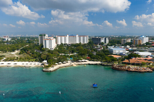 Lapu Lapu Philippines 15 May 2026 Aerial view of modern beachfront resorts and a white sand coastline along the turquoise waters of Mactan Island under a bright sky. Lapu Lapu Philippines 15 May 2026 Aerial view of modern beachfront resorts and a white sand coastline along the turquoise waters of Mactan Island under a bright sky.