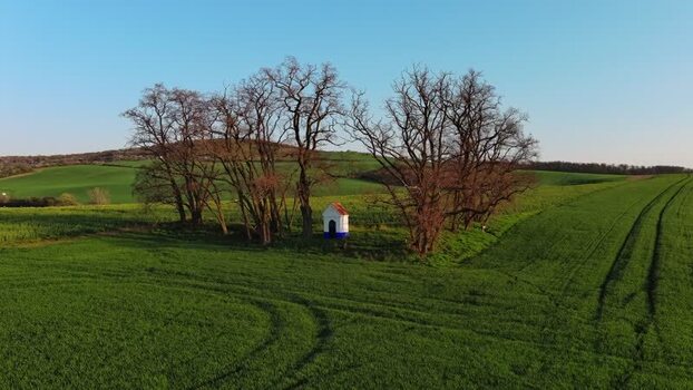 Aerial view of small chapel in green field Czechia.
