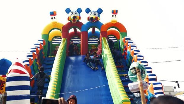 View of children playing on a colorful inflatable slide Bangladesh. View of children playing on a colorful inflatable slide Bangladesh.