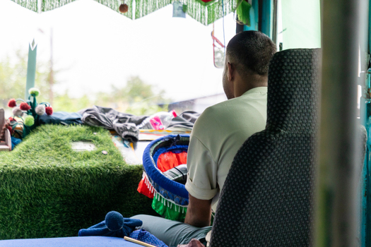 Pokhara Nepal 27 August 2026 View of a bus driver sitting in the driver s seat with a decorated dashboard featuring artificial grass and colorful trim.
