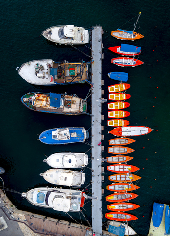 Aerial view of fishing boats and yachts moored at the pier in the Old port of Jaffa with calm dark water and a concrete dock in Tel Aviv Yafo Tel Aviv District Israel.