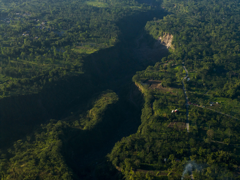 Aerial view of Kali Gendol river valley surrounded by dense tropical forests and rural settlements Cangkringan Special Region of Yogyakarta Indonesia.