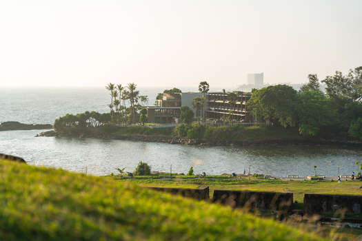 View of a modern coastal resort nestled among palm trees on a peninsula overlooking the Indian Ocean from the historic ramparts Galle Southern Province Sri Lanka.