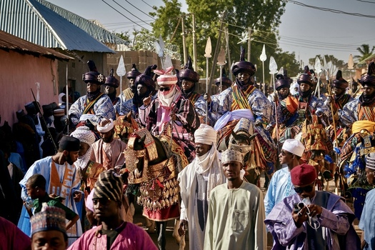 Zaria city Nigeria 21 March 2026 View of a vibrant traditional procession with richly adorned horsemen carrying spears moving through a bustling street filled with onlookers. Zaria city Nigeria 21 March 2026 View of a vibrant traditional procession with richly adorned horsemen carrying spears moving through a bustling street filled with onlookers.