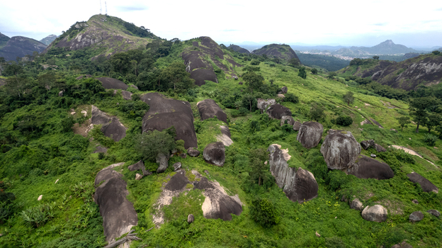Aerial view of Idanre Hill featuring massive granite boulders and lush green vegetation across the landscape in Idanre Ondo State Nigeria. Aerial view of Idanre Hill featuring massive granite boulders and lush green vegetation across the landscape in Idanre Ondo State Nigeria.