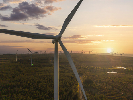 Aerial view of wind turbines at Whitelee Wind Farm on Eaglesham Moor with a sunset sky over the forest landscape Kilmarnock Scotland United Kingdom.