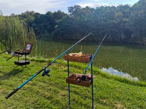 View of fishing rods and tackle boxes positioned on the grassy bank of the Crocodile River in Hartbeespoort North West South Africa. View of fishing rods and tackle boxes positioned on the grassy bank of the Crocodile River in Hartbeespoort North West South Africa.