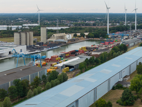 Genk Belgium 27 August 2026 Aerial view of the Kolenhaven industrial port featuring a container terminal inland shipping barges large warehouses and wind turbines.