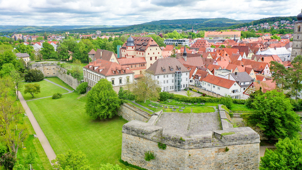 Aerial view of Stadtpark and historic stone fortifications surrounded by traditional red roofed buildings and lush green trees in Forchheim Bayern Germany. Aerial view of Stadtpark and historic stone fortifications surrounded by traditional red roofed buildings and lush green trees in Forchheim Bayern Germany.