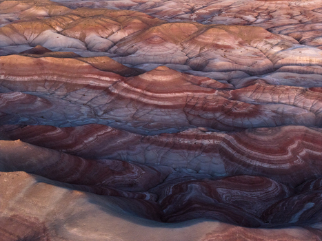 Aerial view of the colorful bentonite hills with vibrant red and purple sedimentary layers in the desert landscape near Hanksville Utah United States.