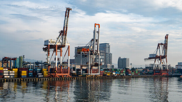 View of Cebu Port Authority with large shipping cranes stacked colorful containers and modern buildings in the background at Cebu City Central Visayas Philippines. View of Cebu Port Authority with large shipping cranes stacked colorful containers and modern buildings in the background at Cebu City Central Visayas Philippines.