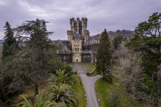 Aerial view of the historic Butron Castle surrounded by dense forest and lush greenery in Butroi Euskadi Spain. Aerial view of the historic Butron Castle surrounded by dense forest and lush greenery in Butroi Euskadi Spain.