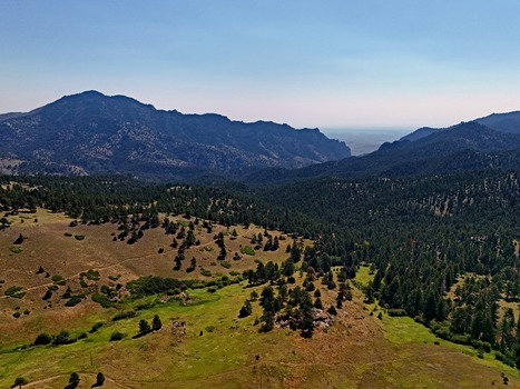 Aerial view of Crescent Meadows Trailhead surrounded by lush green meadows dense pine forests and rugged mountain ridges in Golden Colorado United States. Aerial view of Crescent Meadows Trailhead surrounded by lush green meadows dense pine forests and rugged mountain ridges in Golden Colorado United States.