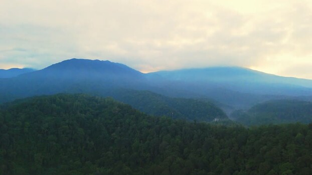 Aerial view of misty mountains and lush forests in Indonesia. Aerial view of misty mountains and lush forests in Indonesia.