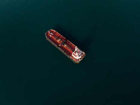 Aerial view of a large red and white industrial tanker ship floating on the calm dark blue water Augusta Sicily Italy. Aerial view of a large red and white industrial tanker ship floating on the calm dark blue water Augusta Sicily Italy.