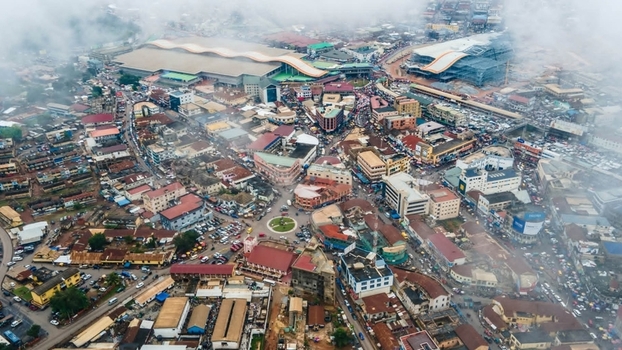 Aerial view of the dense urban cityscape of Kumasi featuring the large Kejetia Market complex bustling streets numerous vehicles and surrounding buildings in Ghana. Aerial view of the dense urban cityscape of Kumasi featuring the large Kejetia Market complex bustling streets numerous vehicles and surrounding buildings in Ghana.
