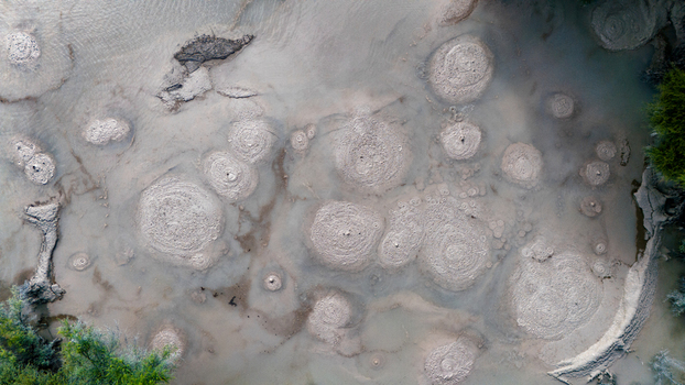 Aerial view of circular patterns etched into the Waiotapu Thermal Wonderland s geothermal landscape a symphony of muted earth tones Waiotapu Waikato Region New Zealand. Aerial view of circular patterns etched into the Waiotapu Thermal Wonderland s geothermal landscape a symphony of muted earth tones Waiotapu Waikato Region New Zealand.