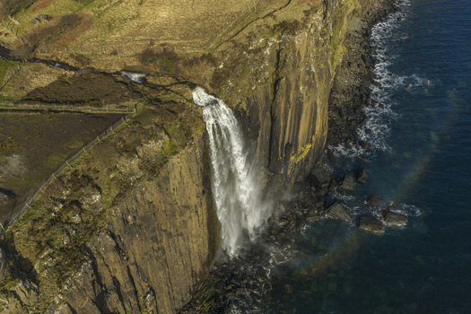 Aerial view of Mealt Falls cascading down the basalt cliffs of Kilt Rock into the sea on the Isle of Skye Scotland United Kingdom. Aerial view of Mealt Falls cascading down the basalt cliffs of Kilt Rock into the sea on the Isle of Skye Scotland United Kingdom.
