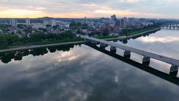 Aerial view of the Harvey Taylor Bridge over the Susquehanna River with the Harrisburg skyline and state capitol dome at sunset Harrisburg Pennsylvania United States.