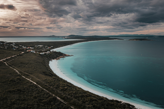 Aerial view of Frenchman Bay with turquoise waters white sandy beach coastal vegetation and dramatic cloudy sky in Albany Western Australia Australia. Aerial view of Frenchman Bay with turquoise waters white sandy beach coastal vegetation and dramatic cloudy sky in Albany Western Australia Australia.