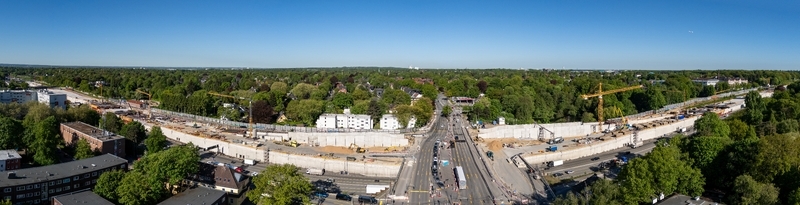 Aerial view of the large scale highway construction site in Bahrenfeld featuring yellow cranes and concrete walls surrounded by green trees in Hamburg Hamburg Germany.