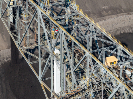 Aerial view of the Tagebau Welzow Sud brown coal open pit mine featuring a massive steel conveyor bridge and industrial extraction machinery in Spremberg Brandenburg Germany. Aerial view of the Tagebau Welzow Sud brown coal open pit mine featuring a massive steel conveyor bridge and industrial extraction machinery in Spremberg Brandenburg Germany.