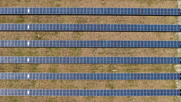 Aerial view of rows of solar panels contrasting against the dry grass creating a geometric pattern from above Elkton Florida United States. Aerial view of rows of solar panels contrasting against the dry grass creating a geometric pattern from above Elkton Florida United States.