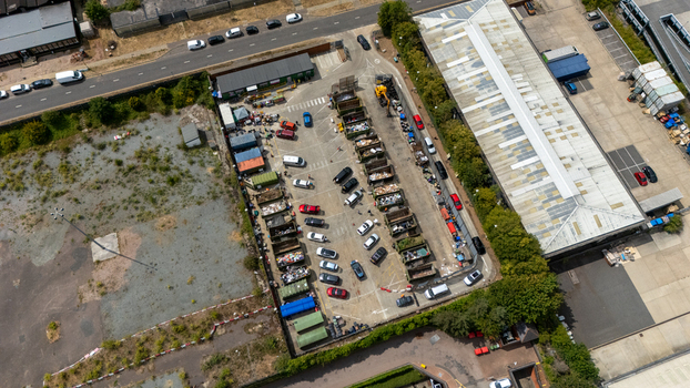 Aerial view of Stevenage Recycling Centre with cars parked in bays and rows of large waste containers at an industrial facility in Stevenage England United Kingdom.