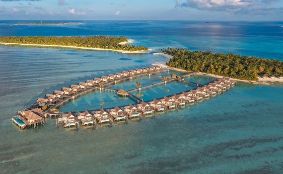 Aerial view of overwater bungalows arranged in a large oval shape over the turquoise lagoon of a tropical island resort near Kudahuvadhoo Dhaalu Atoll Maldives. Aerial view of overwater bungalows arranged in a large oval shape over the turquoise lagoon of a tropical island resort near Kudahuvadhoo Dhaalu Atoll Maldives.
